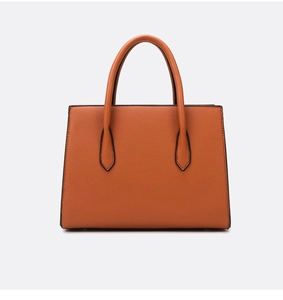 Detail of caramel tote bag showing textured pebble leather and round handles