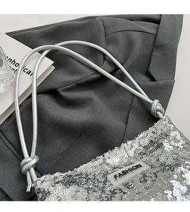 Détail du sac à bandoulière à paillettes argentées avec bandoulière nouée et logo