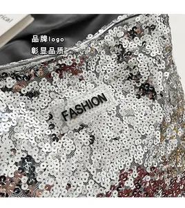 Vue détaillée d'un sac à paillettes argentées avec logo FASHION central en relief