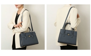 Detail of navy blue tote featuring crocodile pattern texture and gold metallic clasp