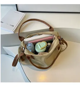 Top view of spacious canvas tote bag interior showing books, umbrella, and water bottle