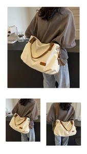 Detail view of large white canvas tote bag with brown leather straps and brand patch