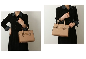 Detail of elegant crocodile-patterned tote bag with golden lock and sturdy handles