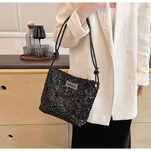 Détail du sac à bandoulière en paillettes noires avec sangle et étiquette FASHION