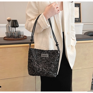 Détail des paillettes noires scintillantes et de l'étiquette FASHION sur ce sac seau