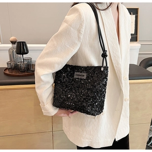 Détail d'un sac à bandoulière à paillettes noires avec sangle nouée et logo FASHION