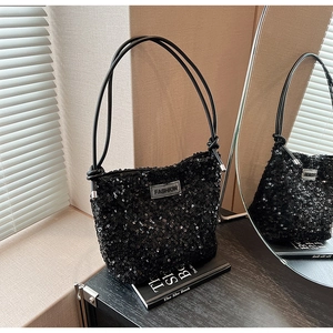 Gros plan du sac bandoulière à paillettes noires avec étiquette FASHION et texture
