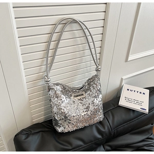Détail du sac à bandoulière à paillettes argentées avec poignées en cuir et logo
