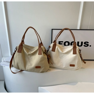 Minimalist canvas tote bags in khaki and cream white on a modern display stand