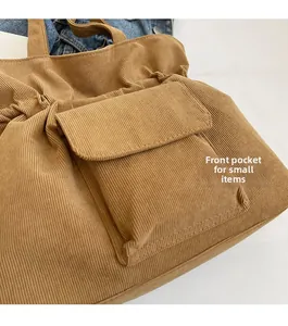 Detail of corduroy tote bag featuring a practical front flap pocket for small items