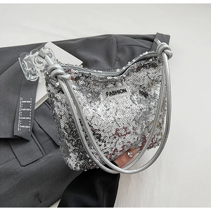 Détail d'un sac argenté à paillettes avec étiquette Fashion et bandoulière nouée
