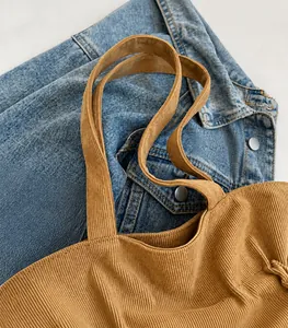 Detail view of brown corduroy tote bag showing wide shoulder strap and soft texture