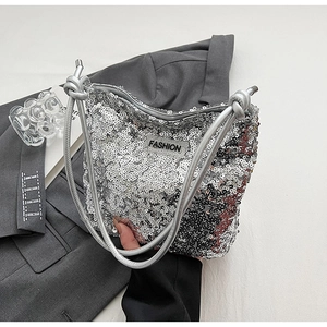 Détail d'un sac à paillettes argentées avec poignées nouées et étiquette de mode chic