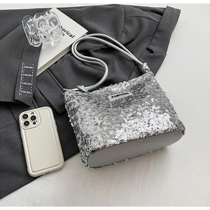 Détail du sac à bandoulière pailleté argenté avec surface scintillante et étiquette