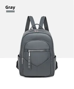 Detailed front view of grey PU leather backpack with litchi texture and front zipper pocket