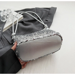 Gros plan d'un sac bandoulière à paillettes argentées montrant les détails des nœuds