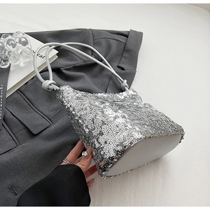 Détail de la texture à paillettes argentées et de la fine bandoulière d'un sac chic