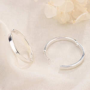 Minimalist S925 sterling silver hoop earrings with flat polished surface on linen background
