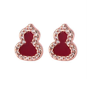 Macro shot of rose gold gourd earrings with red agate center and crystal pavé detailing