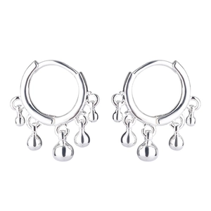 Detailed view of silver hoop earrings with five polished metallic tassel balls
