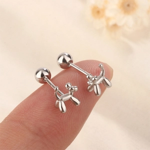 Macro view of balloon dog stud earring in 925 silver with screw back on fingertip