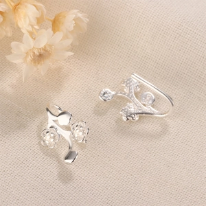 Detailed close-up of S925 silver plum blossom ear hooks on soft textured fabric