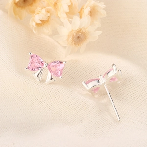Dettaglio degli orecchini a fiocco in argento con zirconi rosa a forma di cuore