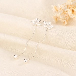 Detail of S925 silver lotus thread earrings with long tassels on linen background