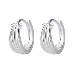 Macro detail of multilayer silver hoop earrings featuring S925 hallmark and woven texture
