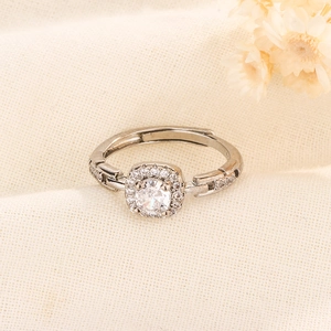 Détail d'une bague ajustable argentée avec solitaire rond et halo de zircons