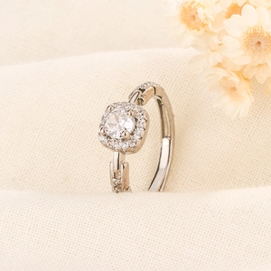 Détail d'une bague argentée avec zircon carré et design d'anneau en chaîne à maillons