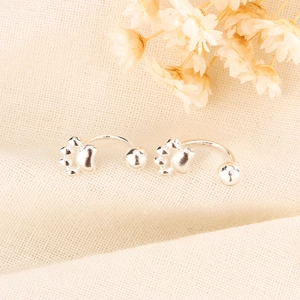 Detailed shot of silver cat paw earrings with S925 hallmark on minimalist screw hooks
