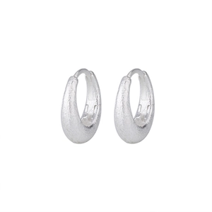 Detail of matte silver oval hoop earrings with a brushed metallic texture finish