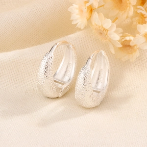 Close-up of matte silver S925 sterling silver hoop earrings with a textured finish