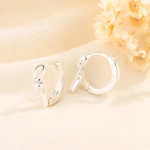 Macro detail of S925 sterling silver hoop earrings with zircon and rectangular charms