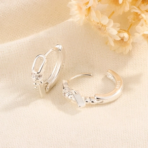 Close-up of S999 sterling silver geometric hoop earrings with zircon pendant and hallmark