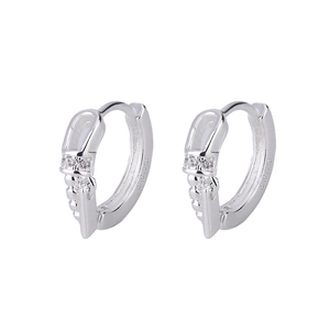 Close-up of geometric hoop earrings with polished chain texture and zircon inlay