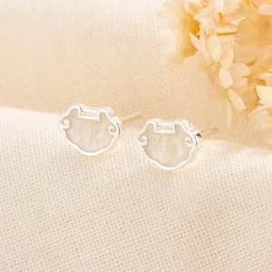 Gros plan de boucles d'oreilles Ruyi en argent avec incrustation de nacre blanche