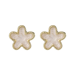 Detailed macro view of gold-trimmed five-petal flower earrings with white enamel