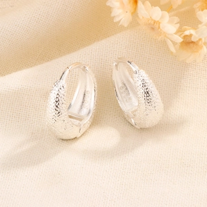 Frosted S925 sterling silver hoop earrings with matte finish on textured linen