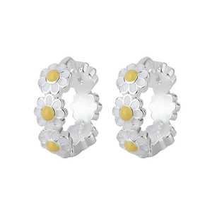 Détail des créoles marguerites avec pétales en émail blanc et centre jaune brillant