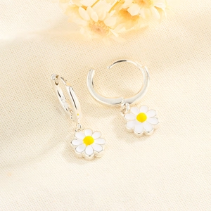 Close-up of silver daisy hoop earrings featuring S925 hallmark and white enamel petals