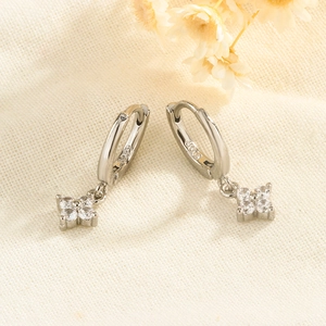 Detailed macro view of S925 silver four-leaf clover earrings with sparkling zircon stones