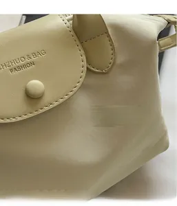 Close-up of beige nylon oxford fabric and leather handle with ZHZHUO logo embossing