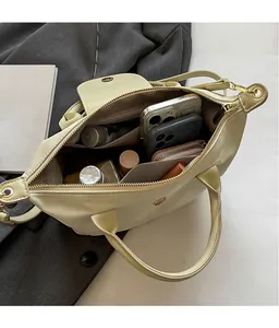 Macro detail of spacious inner compartments in cream oxford fabric handbag with gold zipper