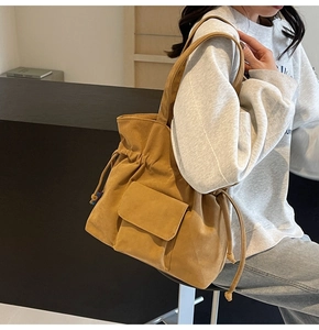 Detail view of ginger corduroy tote bag with drawstring closure and front pocket