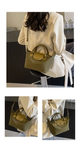 Detail of olive green nylon bag showing brown leather flap with metal buckle design