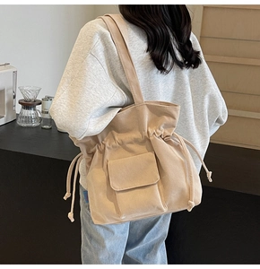 Detailed view of beige corduroy tote bag with drawstring closure and front flap pocket