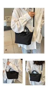 Close-up of black nylon handbag with leather handles and detachable shoulder strap