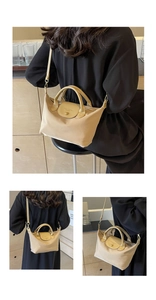 Detail of khaki nylon crossbody bag with leather handles and detachable shoulder strap